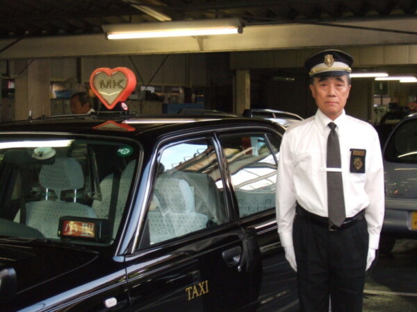 タクシー車両の前で　MK新聞2009年8月1日号より