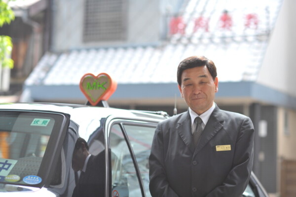 タクシー車両と中村壽男社員（2012年）