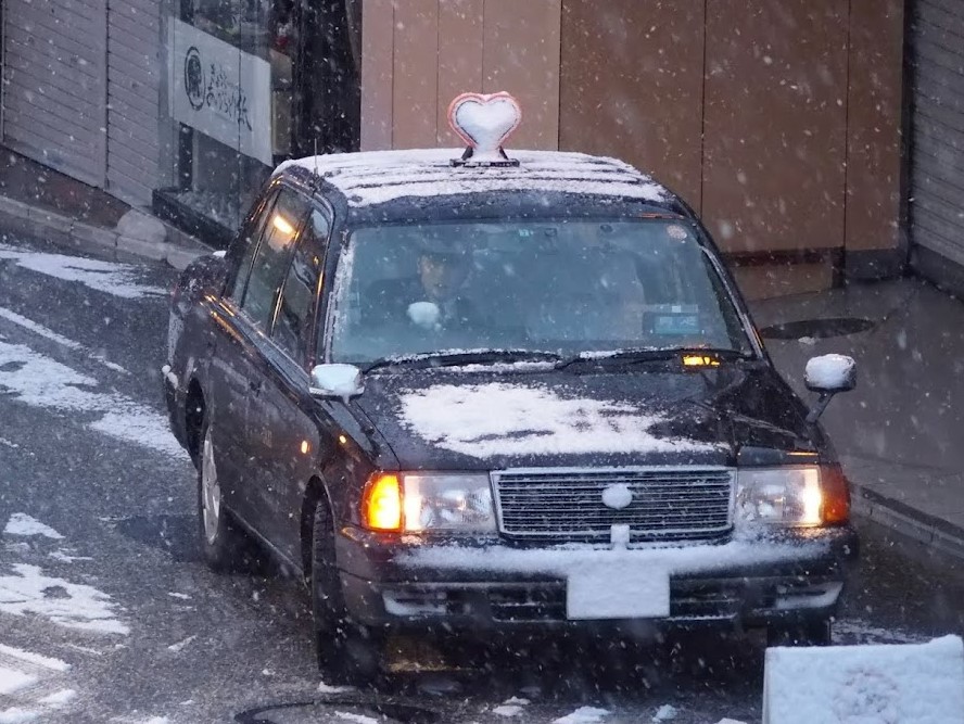 行灯が雪で覆われたMKタクシー