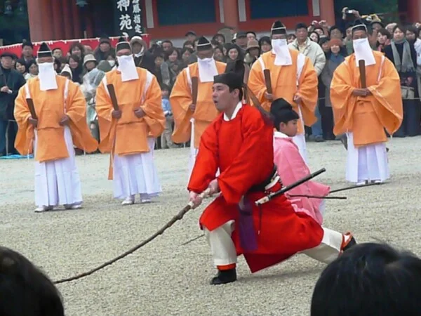 平安神宮で桃の枝を振る様子